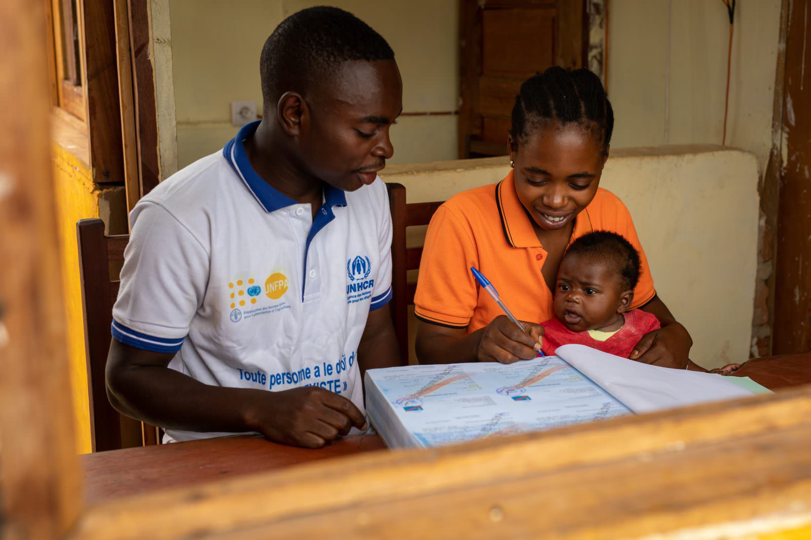 On November 13, 2021, Raphaël Yuse, Civil Registry officer, registers the birth of Léon Kabengele, 3 months old, in Tabac-Congo, a village situated 25km north of Kalémie, in the province of Tanganyika, east of the Democratic Republic of the Congo. ; In the Tanganyika province, it is estimated that only 35% of births are registered in the Civil Registry. The main reason is the distance from the Civil Status offices: on average, a person has to travel 120km to register the birth of a newborn. In the Democratic Republic of the Congo, parents have 90 days to register the birth of their child. After this deadline, only a supplementary judgment allows registration. As parents often do not have the financial means to pay for the legal procedure, the majority of children grow up without civil documents and are not recognized by the Congolese state. To promote an increase in the registration rate in remote localities and help reduce the risk of statelessness, UNHCR supports the Tanganyika authorities by providing means of transport, motorcycles and bicycles, and proxy books, called village notebook, which allows civil status officers to register births directly in the villages, thus preventing mothers from traveling.